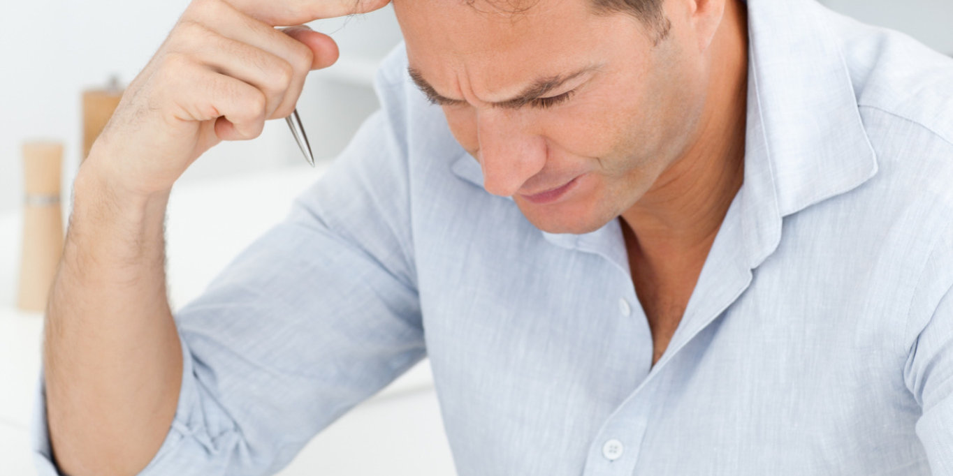 Concentrated man doing a cryptic crossword sitting in his kitchen ThinkstockPhotos Brain