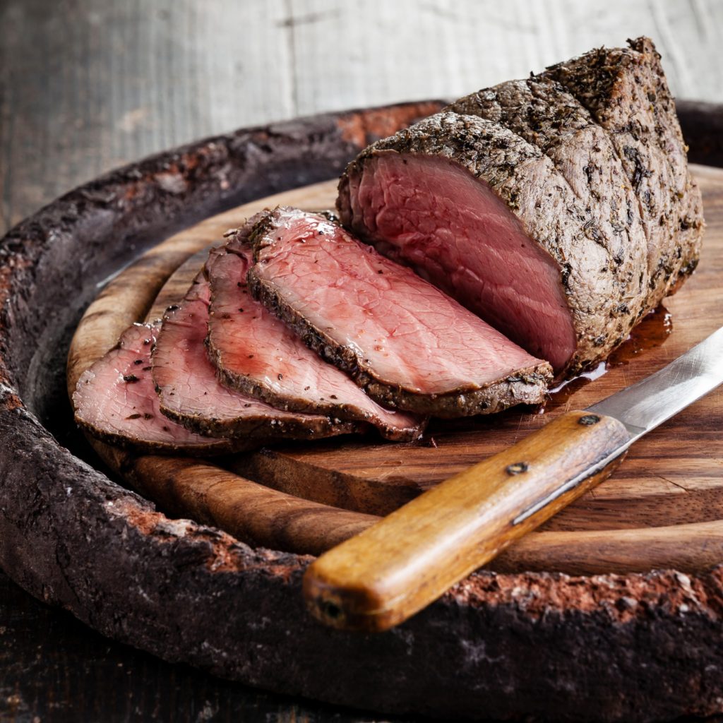 Roast beef on cutting board and knife