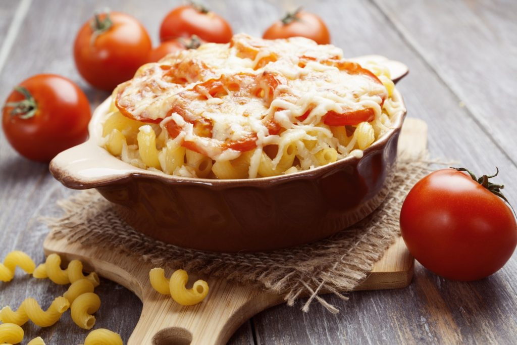 Pasta baked with tomato and cheese in a ceramic pot