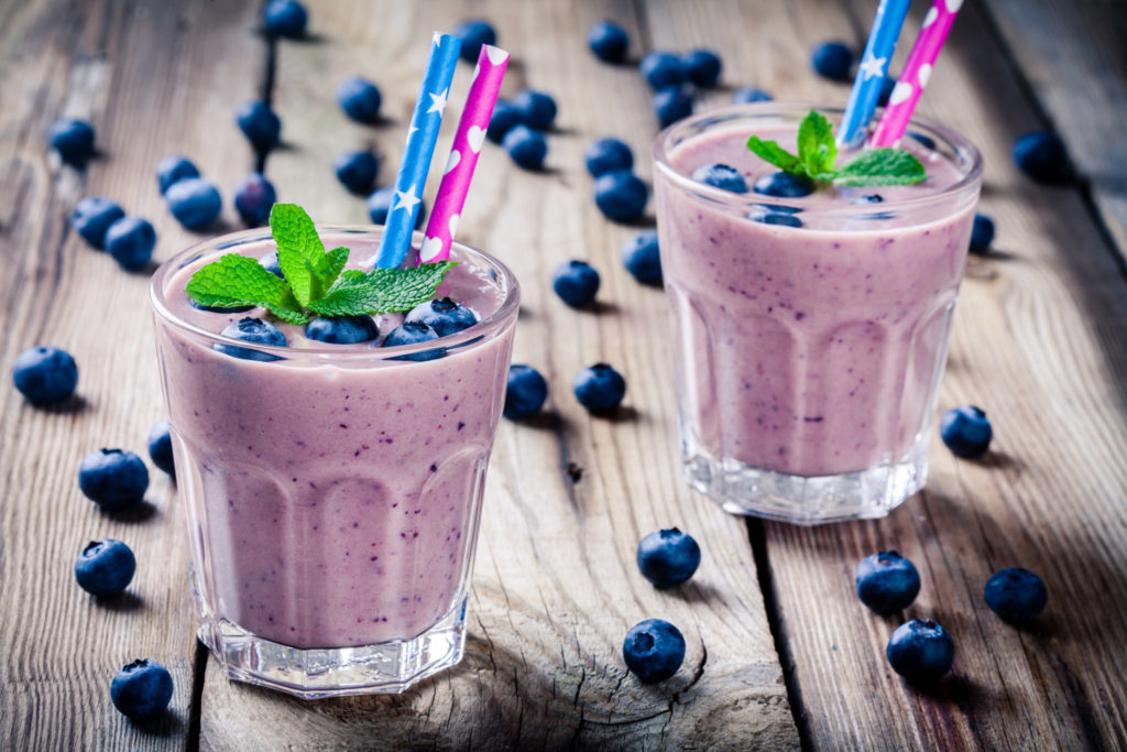 Blueberry smoothie in a glass on a rustic table