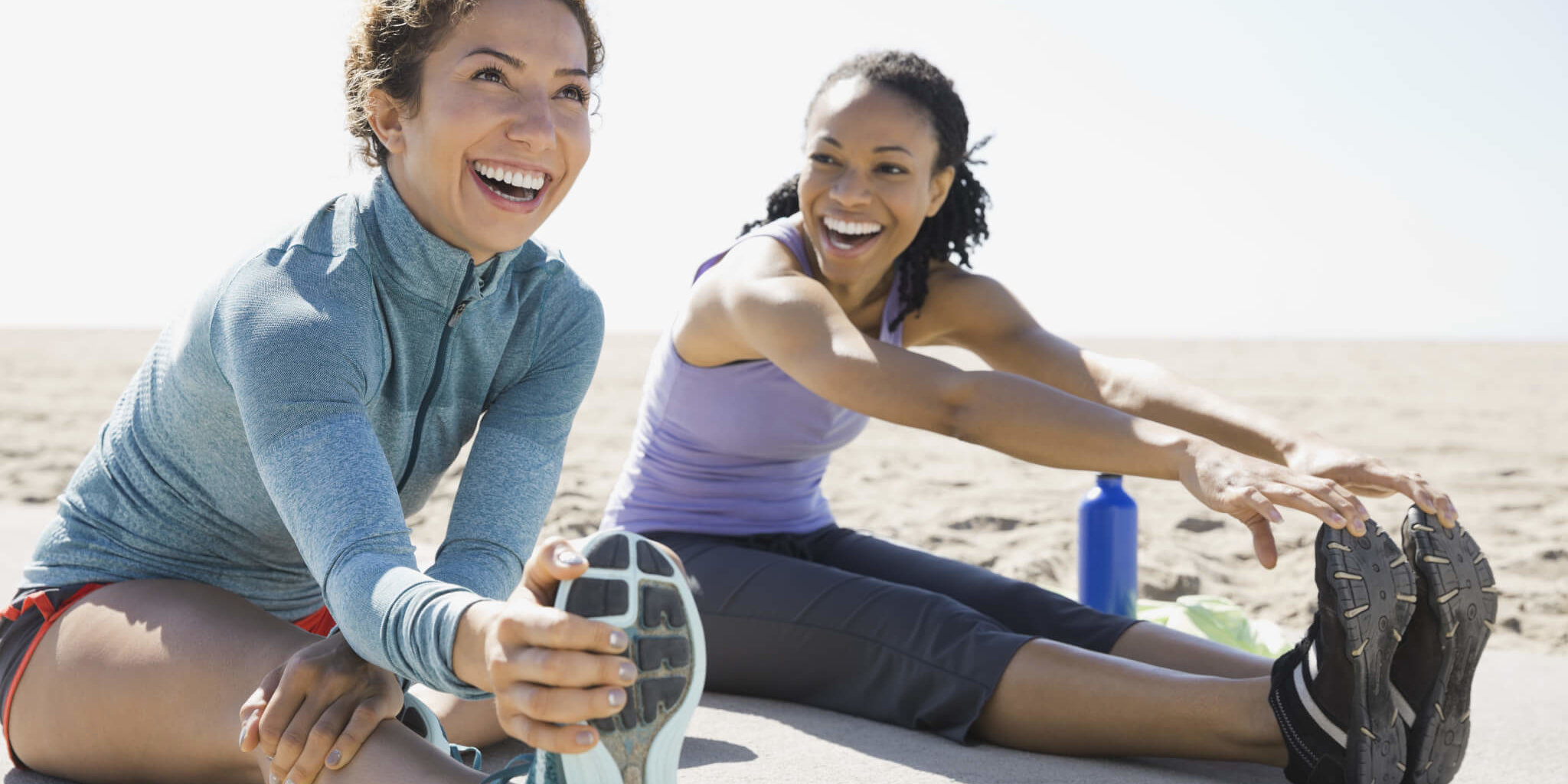 Active women stretching on beach GettyImages