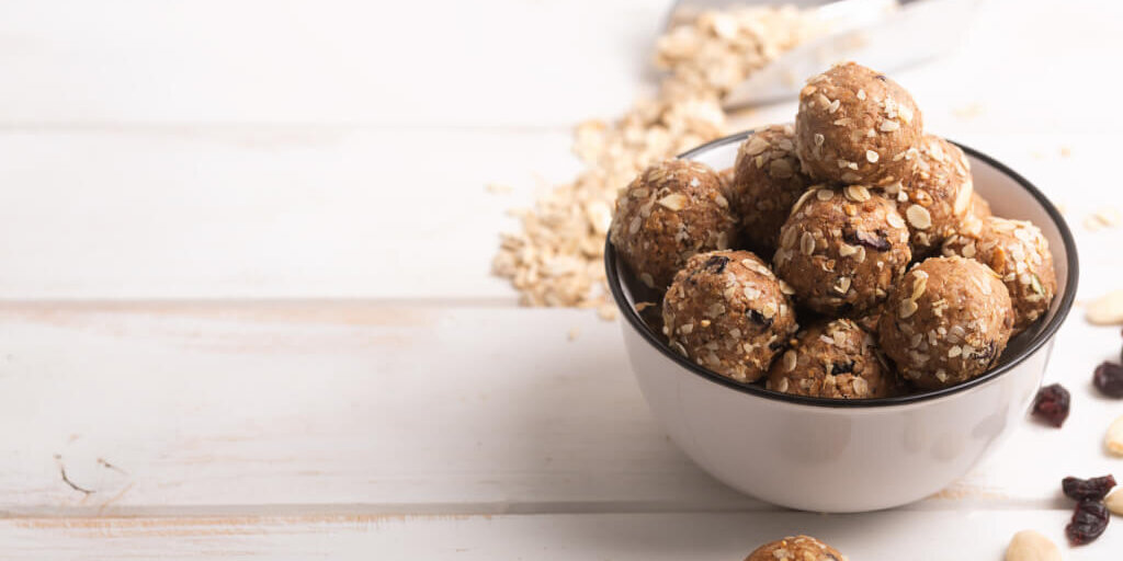 Healthy organic energy granola bolls with nuts, cacao, oats and raisins – vegetarian sweet bites without sugar. Copy space for text lifeshake recipes, protein bites and protein muffins